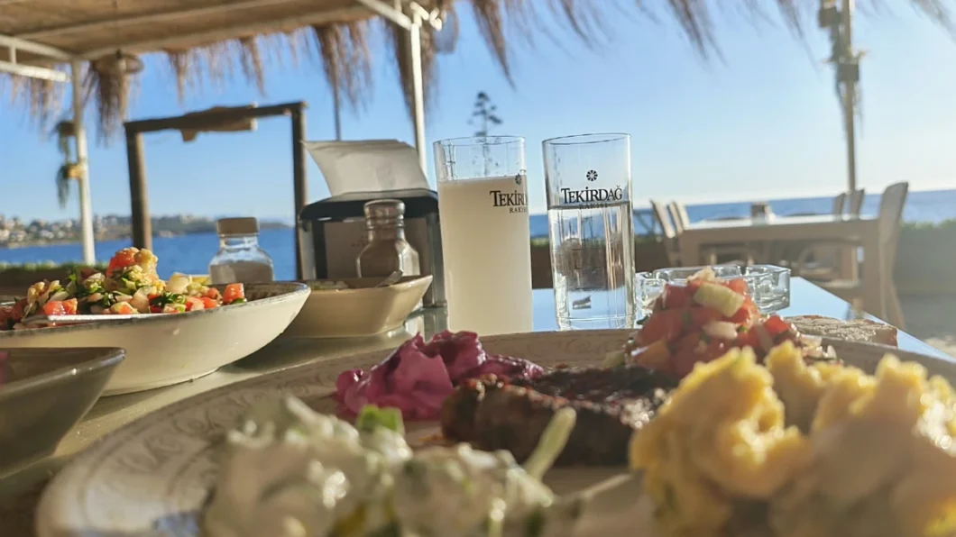 Turkish raki served with water and meze at a seaside table