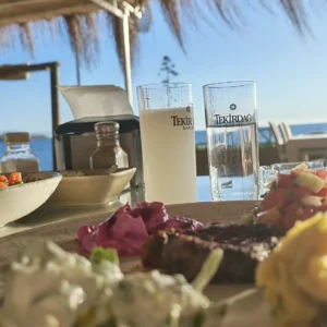 Turkish raki served with water and meze at a seaside table