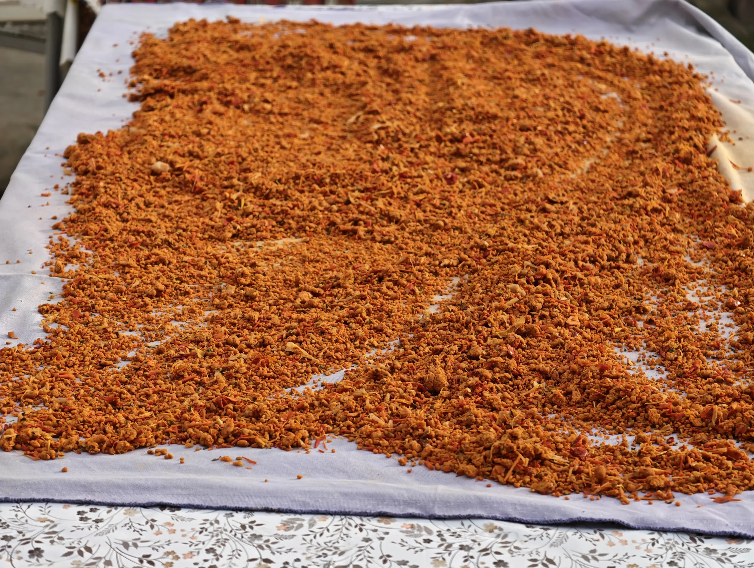 Close-up of crumbled tarhana drying on a white cloth in Seferihisar
