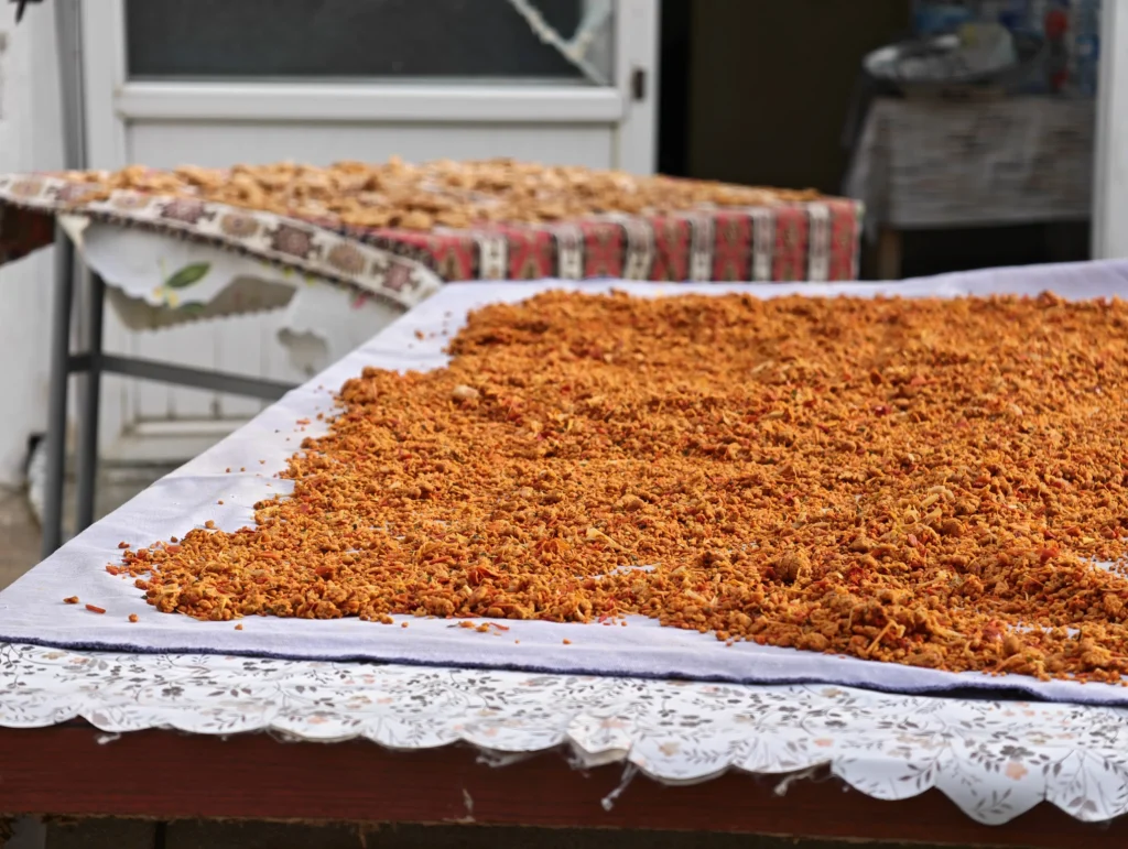 Pieces of homemade tarhana dough drying on a patterned cloth