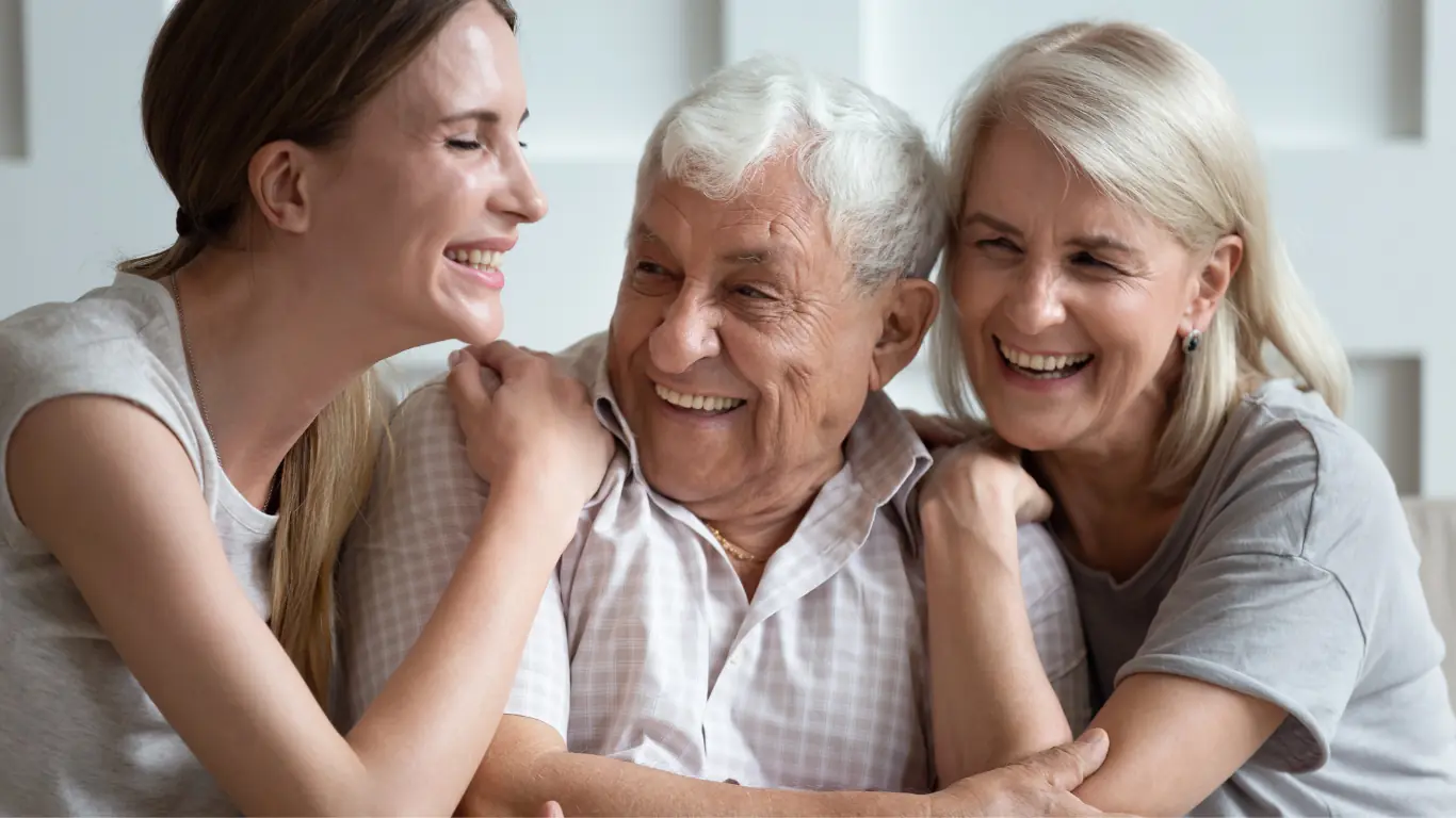 Young woman greeting an elderly couple during a family visit